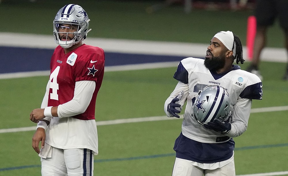 Dallas Cowboys quarterback Dak Prescott (4) and running back Ezekiel Elliott (21) start to line up for a drill during an NFL football training camp in Frisco, Texas, Monday, Aug. 17, 2020. (AP Photo/LM Otero)