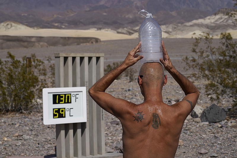 Steve Krofchik cools off with a jug of ice water Monday at Death Valley National Park in California. More photos at arkansasonline.com/819record/. (AP/John Locher) 