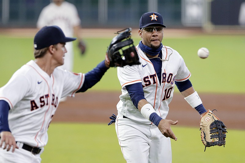 Houston Astros first baseman Yuli Gurriel (10) flips the ball to starting pitcher Zack Greinke (21) as he runs to first base to make the out on Colorado Rockies Garrett Hampson during the sixth inning of a baseball game Tuesday, Aug. 18, 2020, in Houston. (AP Photo/Michael Wyke)