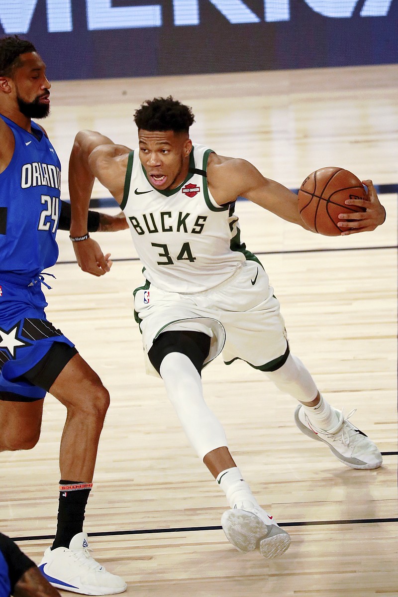 Milwaukee Bucks forward Giannis Antetokounmpo (34) dribbles around Orlando Magic forward Khem Birch (24) during the first half of Game 1 of an NBA basketball first-round playoff series, Tuesday, Aug. 18, 2020, in Lake Buena Vista, Fla. (Kim Klement/Pool Photo via AP)