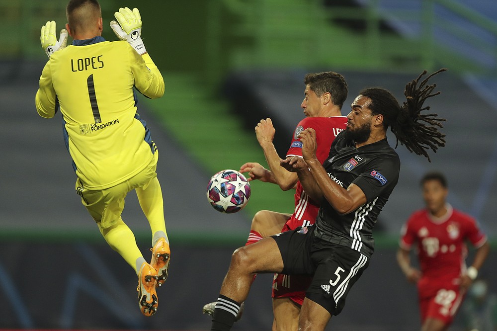 Lyon's Lucas Tousart, right, and Lyon's goalkeeper Anthony Lopes try to stop Bayern's Robert Lewandowski during the Champions League semifinal soccer match between Lyon and Bayern Munich at the Jose Alvalade stadium in Lisbon, Portugal, Wednesday, Aug. 19, 2020. (Miguel A. Lopes/Pool via AP)