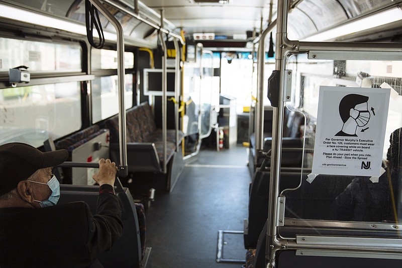 A sign advising passengers to wear face masks is displayed on a New Jersey Transit bus in Atlantic City, New Jersey on Thursday, April 16, 2020. (Bloomberg photo by Angus Mordant)