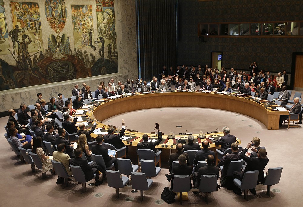FILE - In this July 20, 2015, file photo, members of the Security Council vote at United Nations headquarters on the landmark nuclear deal between Iran and six world powers. The United States is planning a new diplomatic line of attack on Iran after a resounding defeat in the U.N. Security Council. Having lost its long-shot bid to indefinitely extend an international arms embargo on Iran last week, the Trump administration is poised to call for the re-imposition of all U.N. sanctions that had been eased under the 2015 nuclear deal from which the U.S. withdrew two years ago.(AP Photo/Seth Wenig, File)