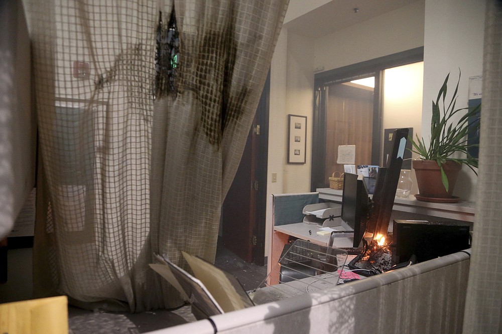 A small fire was set inside of the Multnomah Building during a protest on Tuesday, Aug. 18, 2020, in Portland, Ore. Protesters in Portland broke out the windows of the county government building, sprayed lighter fluid inside and set a fire in a demonstration that started Tuesday night and ended Wednesday morning with clashes with police, officials said. (Beth Nakamura/The Oregonian via AP)