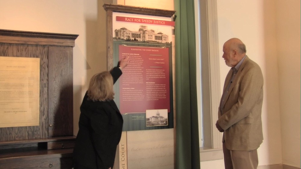 Barbara Webb, justice-elect to the Arkansas Supreme Court, and guest curator Ernie Dumas examine the panels in the new “Arkansas Supreme Court” exhibit at the Old State House Museum.
(Special to the Democrat-Gazette)