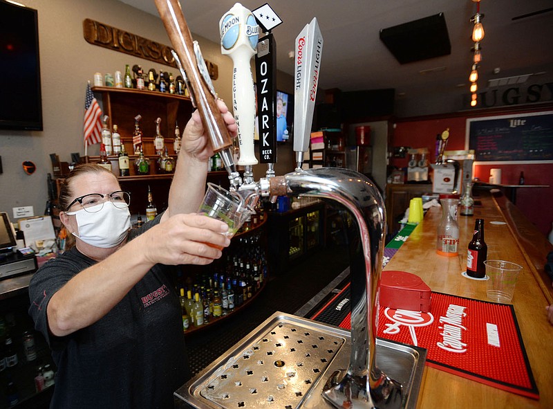 Melissa Broyles-Langley, a bartender at Bugsy's on Dickson Street, pours a draft beer Thursday, Aug. 20, 2020, into a to-go cup at the bar in Fayetteville. The city√¢‚Ç¨≈°√É‚Äû√É¬¥s outdoor refreshment area opened downtown July 22, allowing customers of certain establishments to take drinks outside on designated streets. Visit nwaonline.com/200823Daily/ for today's photo gallery.
(NWA Democrat-Gazette/Andy Shupe)