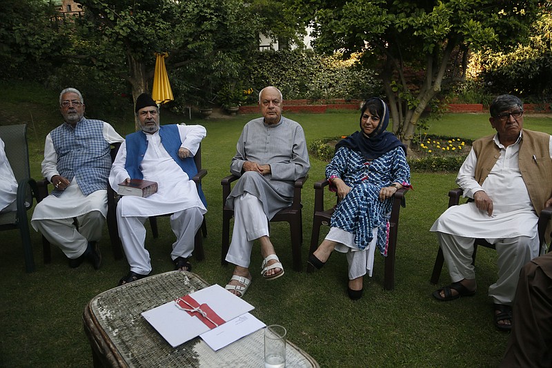 FILE - In this Sunday, Aug. 4, 2019, file photo, National Conference (NC) President Farooq Abdullah, center, Peoples Democratic Party (PDP) leader Mehbooba Mufti, second right, and other leaders sit during an all parties meeting in Srinagar, India. Half a dozen political parties, including NC and PDP, vowed Saturday, Aug. 22, 2020, to fight for restoration of the special status that was stripped last year from Indian-administered Kashmir, setting off widespread anger and economic ruin amid a harsh security clampdown. Four pro-India Kashmiri political parties and two Indian political parties, including the main opposition Congress Party, said in a joint statement that India’s move “unrecognizably changed the relationship” between the region and New Delhi. (AP Photo/Mukhtar Khan)