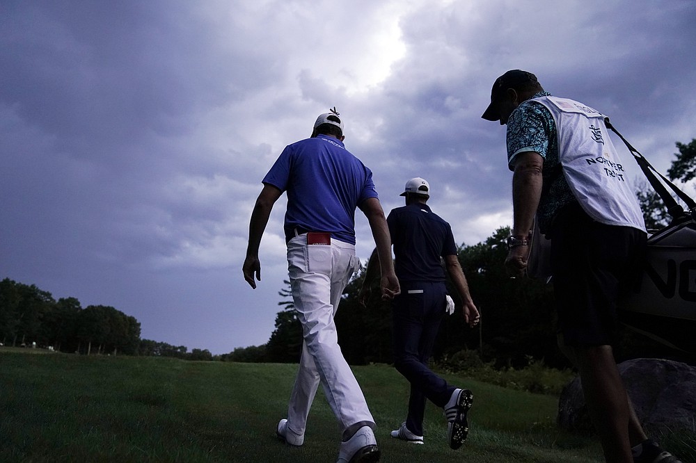 Harris English, left, and Dustin Johnson, center, walk up the fairway on the 18th hole during the final round of the Northern Trust golf tournament at TPC Boston, Sunday, Aug. 23, 2020, in Norton, Mass. (AP Photo/Charles Krupa)