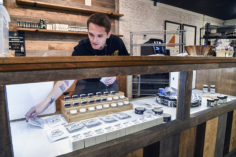 Budtender Tyler Ratliff sets out concentrates for customers to view at Suite 443 Dispensary, 4897 Malvern Ave., on Aug. 12. — Photo by Grace Brown of The Sentinel-Record
