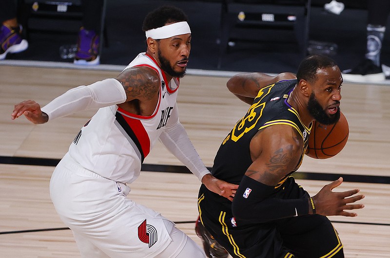 Los Angeles Lakers' LeBron James, right, drives against Portland Trail Blazers' Carmelo Anthony, left, during the second quarter of Game 4 of an NBA basketball first-round playoff series, Monday, Aug. 24, 2020, in Lake Buena Vista, Fla. (Kevin C. Cox/Pool Photo via AP)