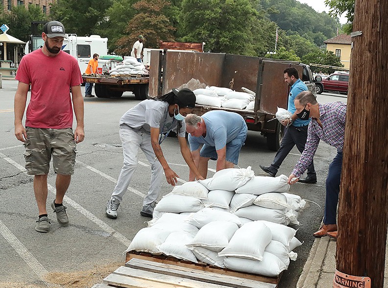 People load sandbags provided by the city of Hot Springs at Hill Wheatley Plaza on Tuesday. -  Photo by Richard Rasmussen of The Sentinel- Record