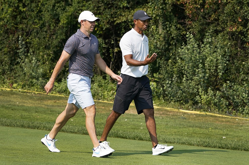Rory McIlroy, left, and Tiger Woods head down the first hole during a practice round Wednesday, Aug. 26, 2020, for the BMW Championship golf tournament at the Olympia Fields Country Club in Olympia Fields, Ill. (AP Photo/Charles Rex Arbogast)