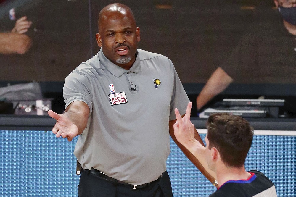 Indiana Pacers head coach Nate McMillan, top, reacts to a call as referee Ben Taylor signals a foul during the first half of Game 3 of an NBA basketball first-round playoff series against the Miami Heat, Saturday, Aug. 22, 2020, in Lake Buena Vista, Fla. (Kim Klement/Pool Photo via AP)