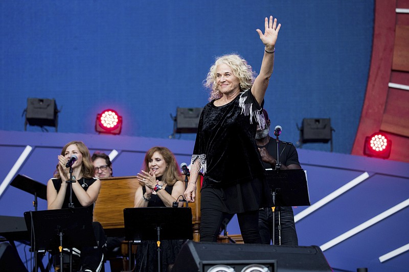 FILE - In this Sept. 28, 2019, file photo, Carole King waves to the crowd as she takes the stage at the 2019 Global Citizen Festival in New York. Poised over the piano, King was set to play “I Feel the Earth Move” during a recent virtual fundraiser for Joe Biden when the Democratic presidential nominee himself beat her to it. “On my playlist, Carole!” Biden proclaimed, holding up his phone and letting a few seconds of the song blast.(AP Photo/Julius Constantine Motal, File)