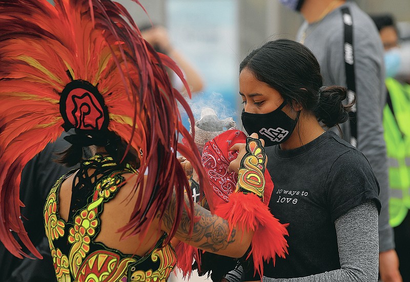A demonstrator receives a traditional Aztec blessing before marching to downtown Los Angeles during a Black Lives Matter protest, Wednesday, June 17, 2020, in Los Angeles. Protesters are asking for the removal of Los Angeles District Attorney Jackie Lacey. (AP Photo/Mark J. Terrill)