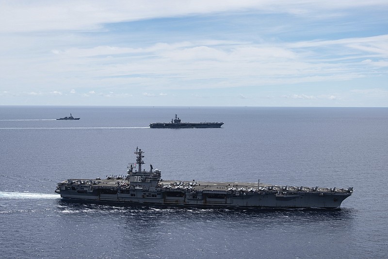 FILE - In this July 6, 2020, file photo provided by U.S. Navy, the USS Ronald Reagan (CVN 76, front) and USS Nimitz (CVN 68, rear) Carrier Strike Groups sail together in formation, in the South China Sea. The U.S. Navy says the aircraft carrier Ronald Reagan and its strike group entered the South China Sea earlier in August, 2020, and have been carrying out air operations.  China routinely objects to U.S. naval activity in the sea, especially when more than one strike group is present, as happened earlier this year, and when they involve operations with navies from other countries.  (Mass Communication Specialist 3rd Class Jason Tarleton/U.S. Navy via AP, File)