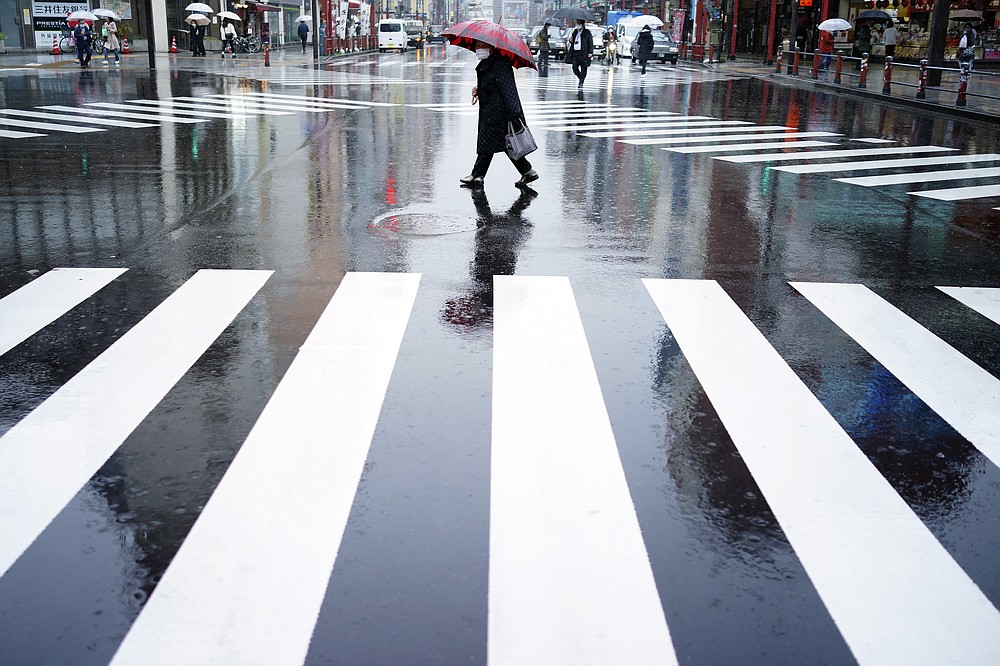 A woman walks in the empty Asakusa district, usually popular with tourists, Wednesday, April 1, 2020, in Tokyo. The United Nations Secretary-General Antonio Guterres on Tuesday, Aug. 25, 2020, said the global tourism industry has been devastated by the coronavirus pandemic, with $320 billion lost in exports in the first five months of the year and more than 120 million jobs at risk. (AP Photo/Eugene Hoshiko, File)