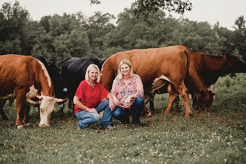 Kay, left, and Kaylee Casey have their photo taken on the family farm with some of their cattle.-Photo Submitted