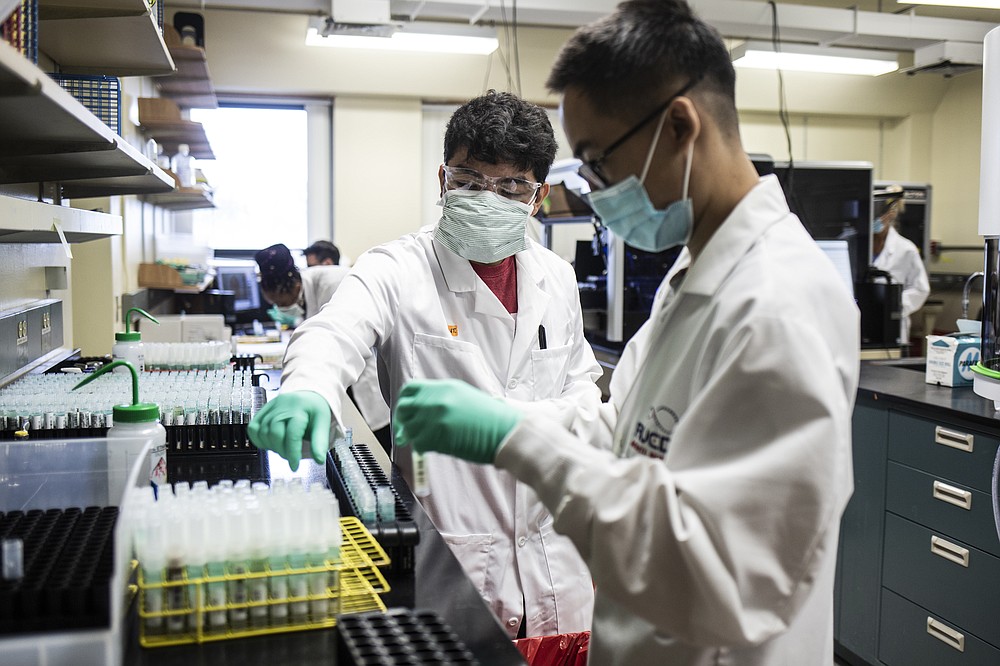 Technicians process coronavirus saliva tests at the Waksman Institute of Microbiology in Piscataway, N.J. MUST CREDIT: photo for The Washington Post by Bryan Anselm.