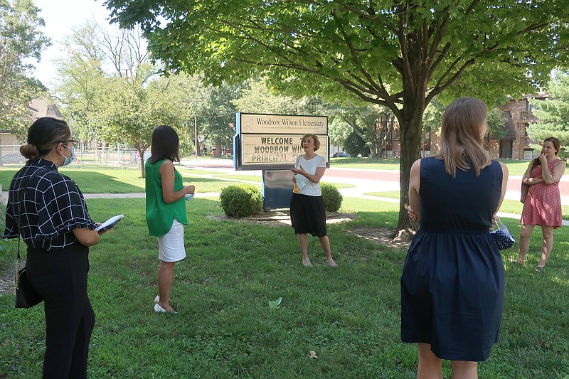 Barbara Bollier, center, the Democratic nominee for an open U.S. Senate seat in Kansas, speaks to half a dozen invited local officials and activists outside an elementary school in Manhattan, Kan., on Aug. 14, 2020. Bollier says she insists on social distancing at in-person events, though she's had mostly virtual ones. (AP Photo/John Hanna)