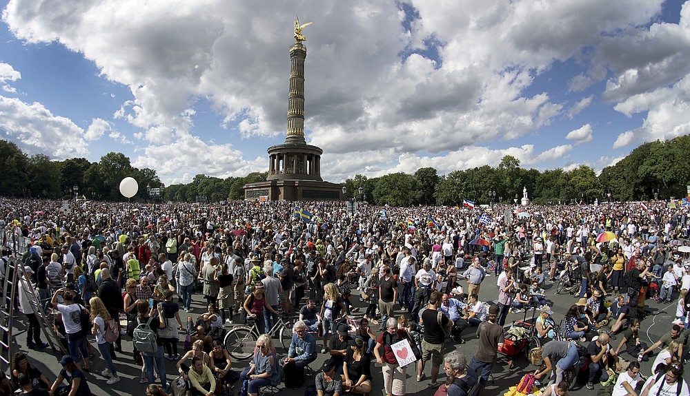 People gather at the Victory Column as they attend a protest rally in Berlin, Germany, Saturday, Aug. 29, 2020 against new coronavirus restrictions in Germany. Police in Berlin have requested thousands of reinforcements from other parts of Germany to cope with planned protests at the weekend by people opposed to coronavirus restrictions. (AP Photo/Michael Sohn)