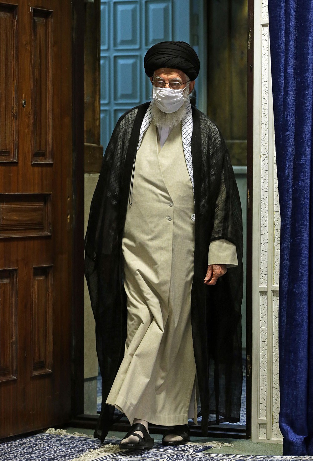 In this picture released by the official website of the office of the Iranian supreme leader, Supreme Leader Ayatollah Ali Khamenei wearing a protective face mask to help prevent spread of the coronavirus arrives to attend a video conference with education ministry officials in Tehran, Iran, Tuesday, Sept. 1, 2020. Iran's supreme leader called the United Arab Emirates' recognition of Israel "treason that will not last for long." (Office of the Iranian Supreme Leader via AP)