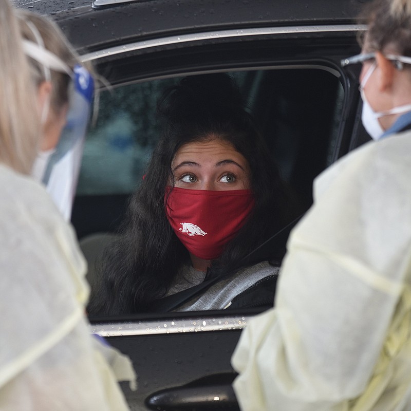 Karson Freeman, a freshman at the University of Arkansas from Little Rock, prepares to insert a long swab Tuesday, September 1, 2020, into her nasal cavity during a drive-through covid-19 testing clinic set up across from Baum-Walker Stadium at the corner of South Razorback Road and West 15th Street in Fayetteville. The Arkansas Department of Health is working with the support of staff from the Pat Walker Health Center to test students, faculty and staff. The drive-through testing will continue today and Thursday from 8:00 a.m. to 2:30 p.m.. The drive through testing is in addition to the covid-19 testing that is available on campus five days a week for University students, faculty and staff. Check out nwaonline.com/200902Daily/ and nwadg.com/photos for a photo gallery.
(NWA Democrat-Gazette/David Gottschalk)