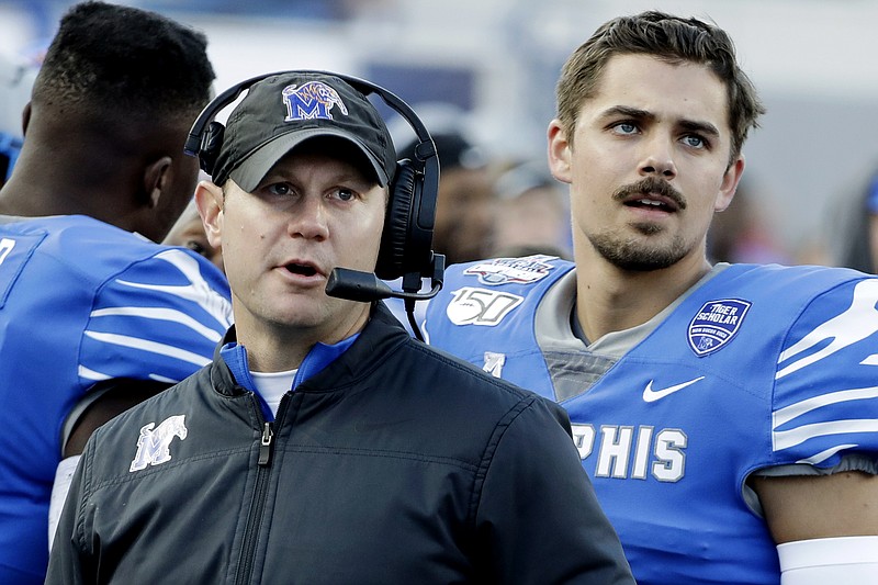 FILE - In this Dec. 7, 2019, file photo, Memphis deputy head coach Ryan Silverfield, left, watches a replay on the scoreboard with quarterback Brady White, right, during an NCAA college football game against Cincinnati for the American Athletic Conference championship in Memphis, Tenn. After winning their first American Athletic Conference last season, the Memphis Tigers want to make sure they do not skip a beat with Silverfield now their third different coach in six seasons. (AP Photo/Mark Humphrey, File)