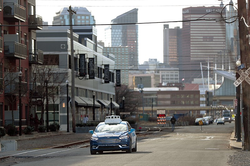 FILE - In this Dec. 18, 2018 file photo, one of the test vehicles from Argo AI, Ford's autonomous vehicle unit, navigates through the strip district near the company offices in Pittsburgh.  The U.S. government’s road safety agency has set up an online map that will let people track where autonomous vehicles are being tested. The National Highway Traffic Safety Administration launched the tool Wednesday, Sept. 2, 2020, showing data about testing on public roads in 17 cities.  (AP Photo/Keith Srakocic, File)