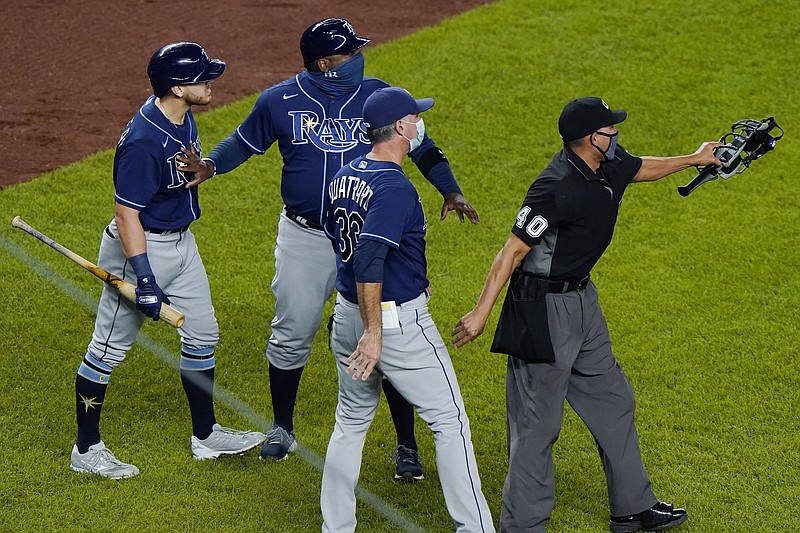 Tampa Bay Rays pinch-hitter Michael Brosseau, left, is restrained by a coach as second base umpire Chad Fairchild (4) warns New York Yankees relief pitcher Aroldis Chapman to stay away from Brosseau as the two players exchanged words following the Rays' 5-3 loss to the Yankees in a baseball game, Tuesday, Sept. 1, 2020, at Yankee Stadium in New York. The altercation started after Chapman threw a high pitch at Brosseau. (AP Photo/Kathy Willens)