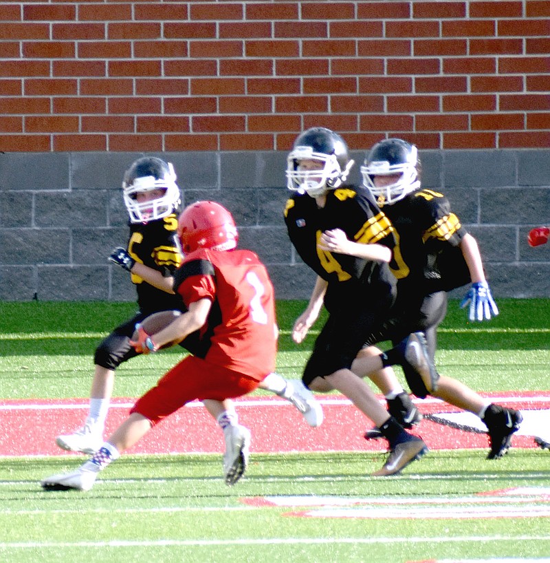 MARK HUMPHREY  ENTERPRISE-LEADER/Farmington seventh grade tailback Dawson Keaton stops on a dime causing Prairie Grove defenders to over-run him enabling him to get into the end zone. Keaton scored three touchdowns in the Cardinals' 22-14 seventh grade win at home Thursday.