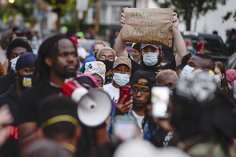 A crowd of protesters gather, Wednesday, Sept. 2, 2020, in Rochester, N.Y., near the site where Daniel Prude was restrained by police officers. Prude, a Black man who had run naked through the streets of the western New York city, died of asphyxiation after a group of police officers put a hood over his head, then pressed his face into the pavement for two minutes, according to video and records released Wednesday by his family. Prude died March 30 after he was taken off life support, seven days after the encounter with police in Rochester. (AP Photo/Adrian Kraus)