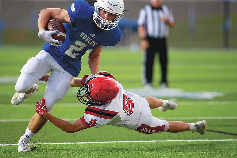 Gavin Pitts (2) of Rogers goes in for Mounties first touchdown during the first quarter as Trevor Austin (9) of Oklahoma Stilwell  tries to make the stop at Whitey Smith Stadium, Rogers High School, Rogers, Arkansas, on Friday, September 4, 2020 / Special to NWA Democrat Gazette