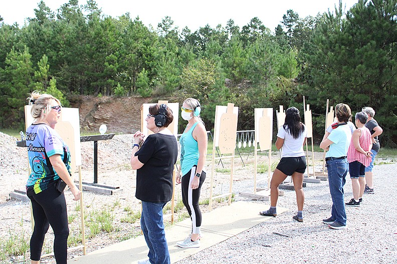 Instructor Staci Claunch, left, talks with a couple of participants taking the Women on Target class on Saturday morning. In this class, Claunch teaches women the basics of firearm shooting and safety. - Photo by Tanner Newton of The Sentinel-Record
