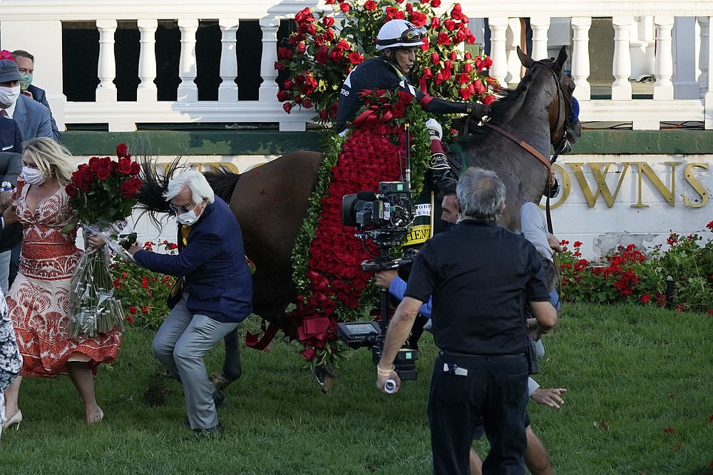 Trainer Bob Baffert is knocked to ground as Jockey John Velazquez try to control Authentic in the winners' circle after winning the 146th running of the Kentucky Derby at Churchill Downs, Saturday, Sept. 5, 2020, in Louisville, Ky. (AP Photo/Jeff Roberson)