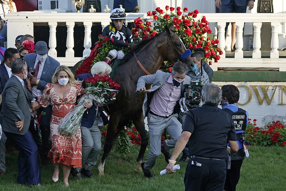 Trainer Bob Baffert attempts to get out of the way as Jockey John Velazquez tries to control Authentic in the winners' circle after winning the 146th running of the Kentucky Derby at Churchill Downs, Saturday, Sept. 5, 2020, in Louisville, Ky. (AP Photo/Jeff Roberson)