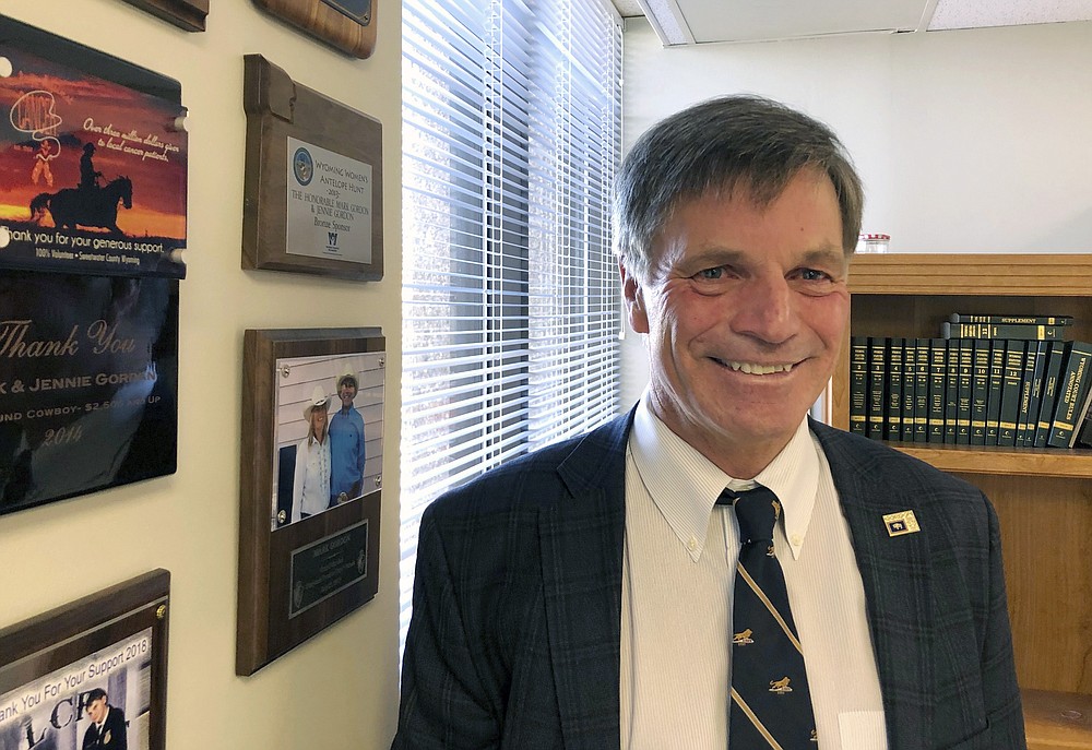 In this file photo taken Dec. 18, 2018, Wyoming Gov. Mark Gordon poses for a photo in a state office in Cheyenne, Wyo. Spending cuts to schools, childhood vaccinations and job-training programs. New taxes on millionaires, cigarettes and legalized marijuana. Borrowing, drawing from rainy day funds and delaying work for months on budget plans. (AP Photo/Mead Gruver, File)
