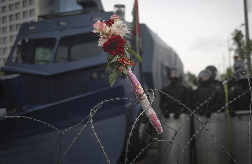 Flowers lie on the barbed wire separating Belarusian servicemen and Belarusian opposition supporters during a rally to protest the official presidential election results in Minsk, Belarus, Sunday, Sept. 6, 2020. Sunday's demonstration marked the beginning of the fifth week of daily protests calling for Belarusian President Alexander Lukashenko's resignation in the wake of allegedly manipulated elections. (AP Photo/TUT.by)