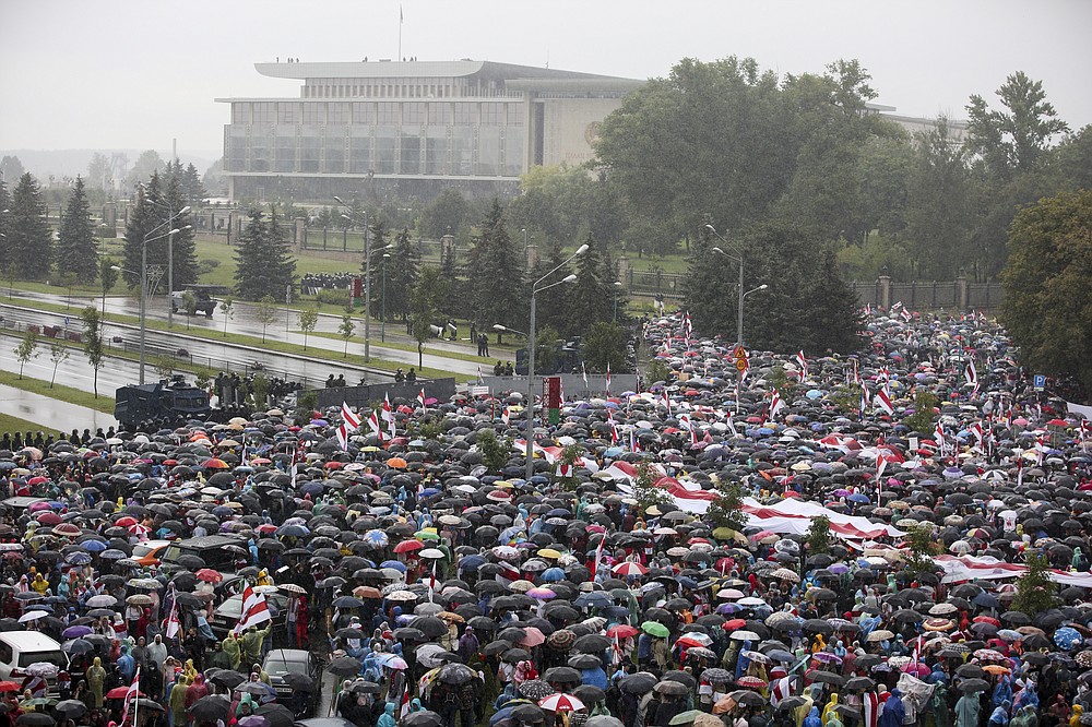 Belarusian opposition supporters gather in front of police line toward the Independence Palace, residence of the President Alexander Lukashenko, in the background, in Minsk, Belarus, Sunday, Sept. 6, 2020. Sunday's demonstration marked the beginning of the fifth week of daily protests calling for Belarusian President Alexander Lukashenko's resignation in the wake of allegedly manipulated elections. (AP Photo/TUT.by)