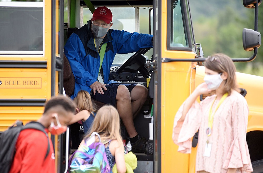 Rob Ariola, bus driver with the Springdale Public School District, greets students Tuesday, September 1, 2020, as they apply hand sanitizer while entering the bus for a ride home from Monitor Elementary School in Springdale. Check out nwaonline.com/200903Daily/ and nwadg.com/photos for a photo gallery.
(NWA Democrat-Gazette/David Gottschalk)