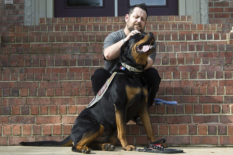 Perry Hopman plays with his service dog, Atlas, outside his home in Benton on Friday, Sept. 4, 2020. Atlas is trained to help Perry ward off panic attacks, anxiety, and flashbacks on the job as a result of his PTSD while serving as a U.S. Army flight medic.

(Arkansas Democrat-Gazette / Stephen Swofford)