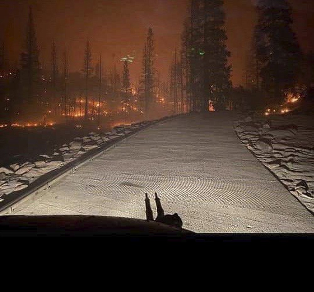 In this Saturday, Sept. 5, 2020, photo released by the California National Guard, shows the view from a Cal Guard Chinook helicopter last night rescuing people trapped after the Creek Fire in central California left them stranded. More than 200 people were airlifted to safety after a fast-moving wildfire trapped them in a popular camping area in California's Sierra National Forest. The California Office of Emergency Services said Black Hawk and Chinook helicopters were used for the rescues that began Saturday night and continued overnight. (California National Guard via AP)