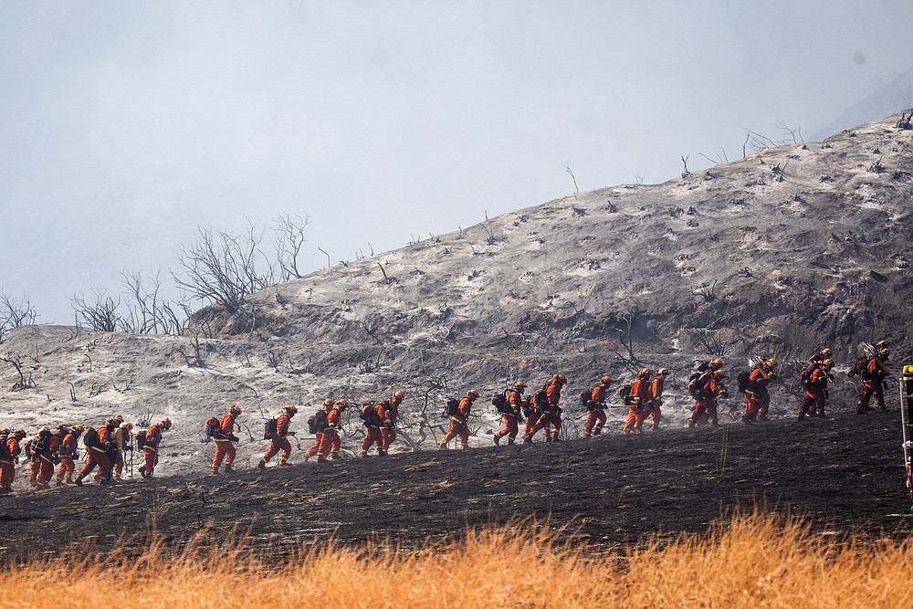 Members of a hand crew work on the fire line in Yucaipa, Calif., Saturday, Sept. 5, 2020. (AP Photo/Ringo H.W. Chiu)
