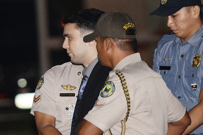 FILE - In this Dec. 1, 2015, file photo, convicted U.S. Marine Lance Cpl. Joseph Scott Pemberton is escorted to his detention cell upon arrival at Camp Aguinaldo at suburban Quezon city, northeast of Manila, Philippines. The Philippine president pardoned the U.S. Marine on Monday, Sept. 7, 2020 in a surprise move that will free him from imprisonment in the 2014 killing of a transgender Filipino woman that sparked anger in the former American colony. (Ted Aljibe/Pool Photo, File)