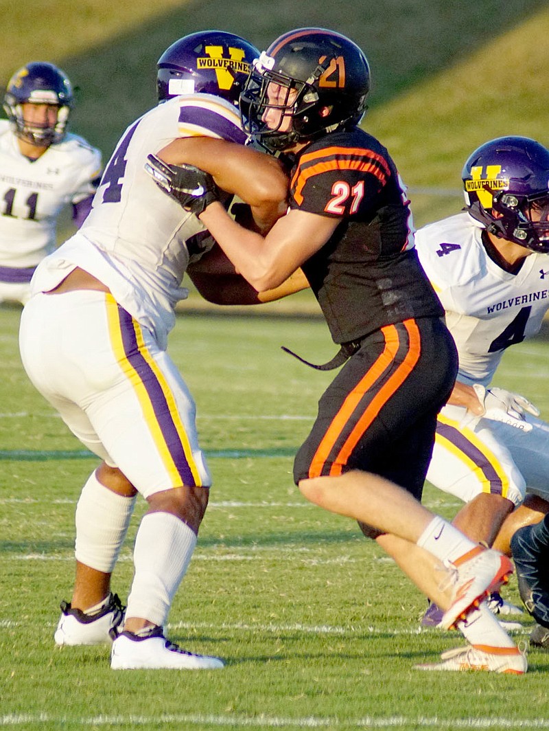 Westside Eagle Observer file photo/RANDY MOLL
Shown playing defense against the Vian, Okla., Wolverines on Aug. 28, Gravette sophomore Karl Bontragerâ€™s (No. 21) second-quarter touchdown run put Gravette ahead to stay as the Lions held off Inola for a road non-conference victory. Bontrager scored from 8 yards out, then added the two-point conversion run to give Gravette (1-1) a 16-13 lead in play Sept. 4, at Inola. Against Pryor, Okla, on Friday, Bontrager set up a touchdown for Gravette with a 30-yard run. Later, he carried the ball across the goal again for another Gravette score.