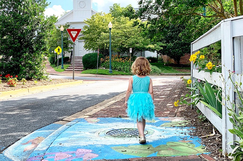 Adelynn Graff walks along street art near the Town Green in Vienna, Va. (The Washington Post/Austin Graff)