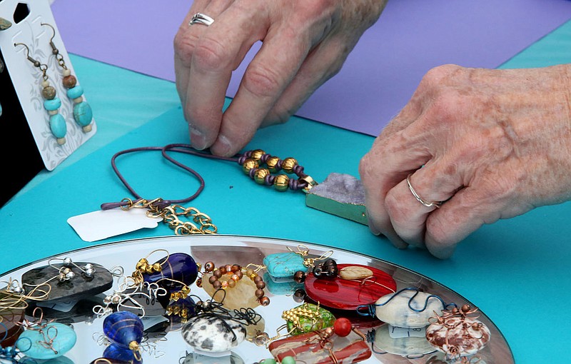 NWA Democrat-Gazette/DAVID GOTTSCHALK  The hands of Mary Ann Boyer, with the Northwest Arkansas Beading Society, are visible as she sets up her bead display area Friday, September 1, 2017, for the 2017 Prairie Grove Clothesline Fair at Prairie Grove Battlefield State Park. The fair features more than entertainment, more than 150 vendors and begins today and runs through Monday.
