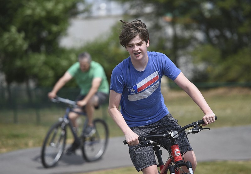 Carson Butler of Springdale (from right) and his dad Gary Butler ride, Sunday, June 21, 2020 at the Runway Bike Park in Springdale. Gary Butler and his son Carson continued their father's day celebration with a ride through the pump tracks. "We drive out here a lot, and I thought we need to do this sometime," he said of the track. Check out nwaonline.com/200622Daily/ for today's photo gallery. 
(NWA Democrat-Gazette/Charlie Kaijo)