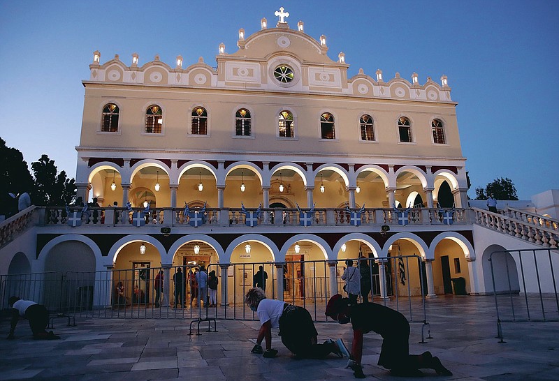 Pilgrims crawl in front of the Holy Church of Panagia of Tinos, on the Aegean island of Tinos, Greece, on Friday, Aug. 14, 2020. For nearly 200 years, Greek Orthodox faithful have flocked to Tinos for the Aug. 15 feast day of the Assumption of the Virgin Mary, the most revered religious holiday in the Orthodox calendar after Easter. But this year there was no procession, the ceremony, like so many lives across the globe, upended by the coronavirus pandemic. (AP Photo/Thanassis Stavrakis)