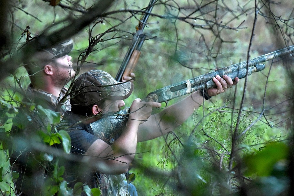 Jake Taylor (left) eyes incoming doves while Matt Hughest takes a shot Sept. 5 2020 on the opening day of dove hunting season.
(NWA Democrat-Gazette/Flip Putthoff)
